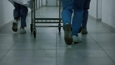未知的医生团队运行走廊滚动格尼医务人员携带担架